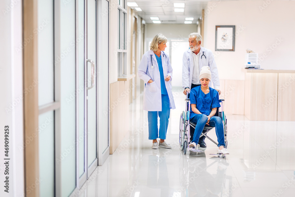 Obraz premium Professional medical doctor team with stethoscope in uniform discussing with patient woman with cancer cover head with headscarf of chemotherapy cancer in hospital.health care concept