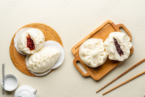 Delicious Baozi, Chinese steamed meat bun is ready to eat on serving plate and steamer. Baozi or Bakpao is a type of yeast-leavened filled bun in various Chinese cuisines. 