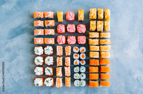 Sushi rolls set on blue background, top view, different types of sushi rolls, Japanese food.