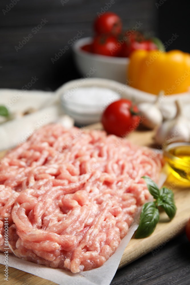 Raw chicken minced meat with basil on black wooden table, closeup Raw chicken minced meat with basil on black wooden table, closeup