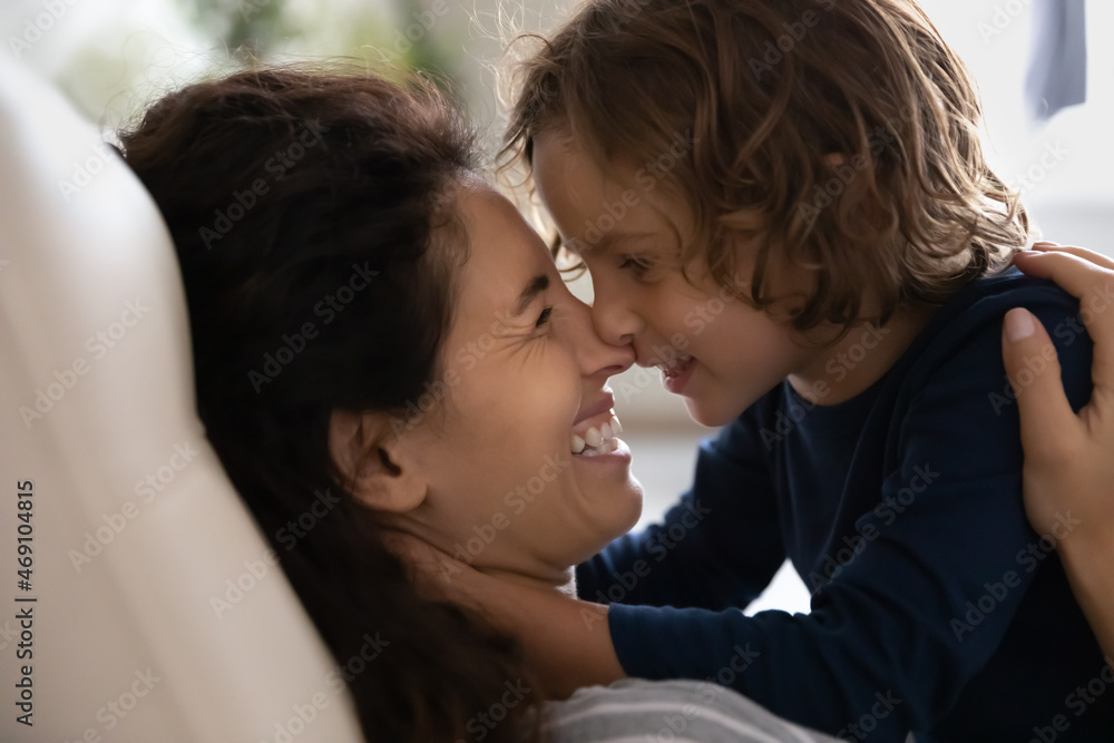 Close up hispanic happy mother and little son touching noses and looking in eyes, family enjoying sharing tender moment, smiling young mom with adorable kid child cuddling, showing love and care