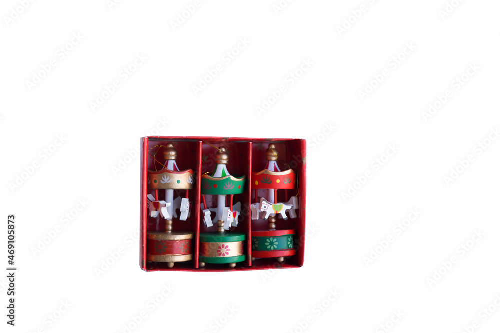 Wooden Christmas toy for the Christmas tree. Eco-friendly toy for Christmas. A small red, green and gold carousel in the form of a tent with white horses made of wood Wooden Christmas toy for the Christmas tree. Eco-friendly toy for Christmas. A small red, green and gold carousel in the form of a tent with white horses made of wood