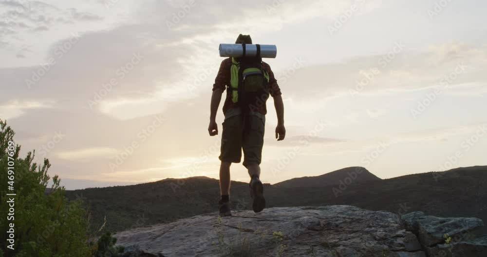 Caucasian male survivalist with arms in the air, celebrating reaching mountain peak in wilderness Caucasian male survivalist with arms in the air, celebrating reaching mountain peak in wilderness