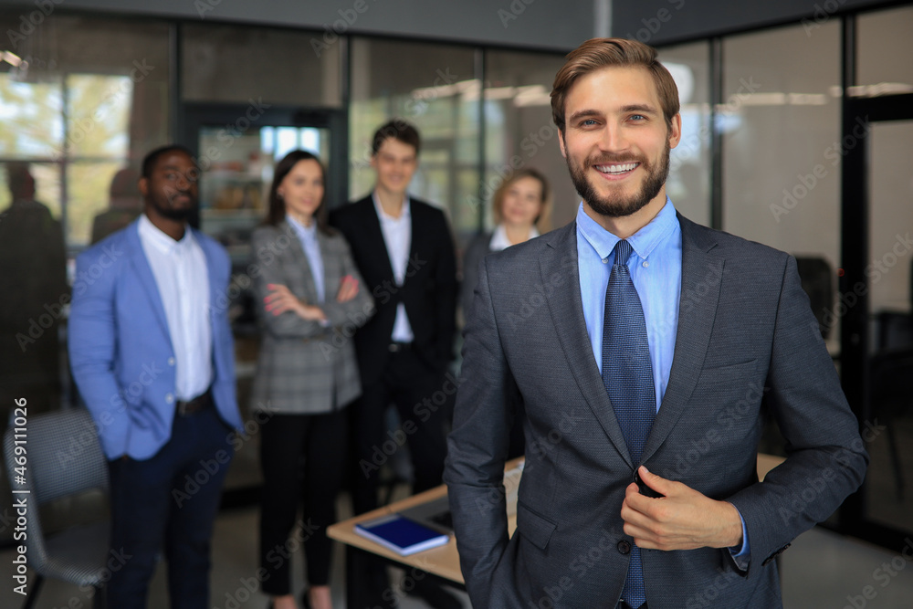 Businessman with colleagues in the background in office. Businessman with colleagues in the background in office.