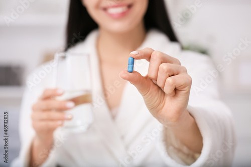 Woman with pill and water i...