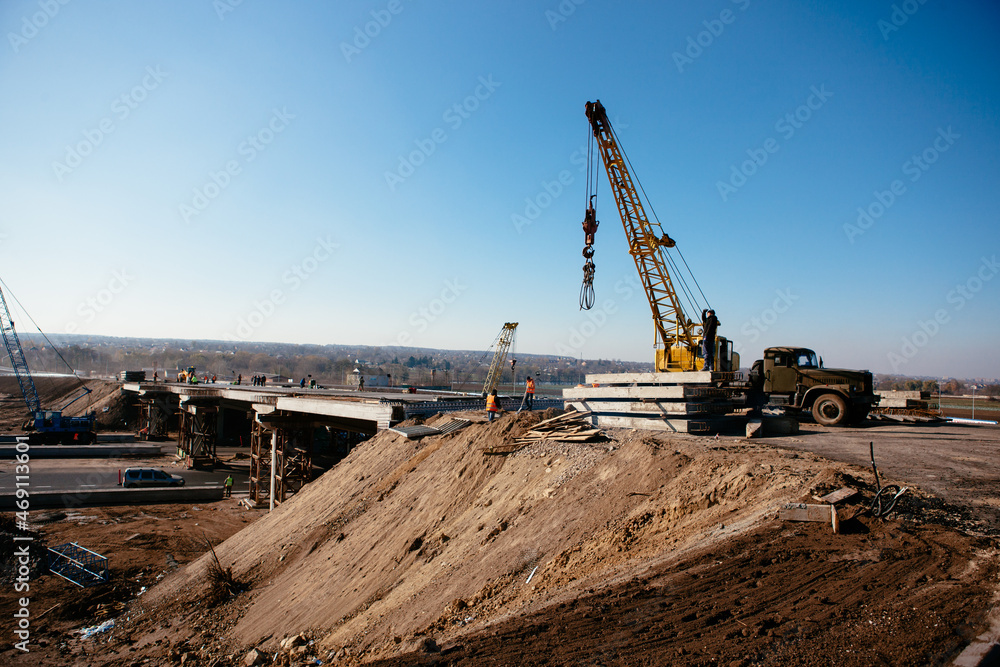 crane on the construction of the bridge on a warm spring morning