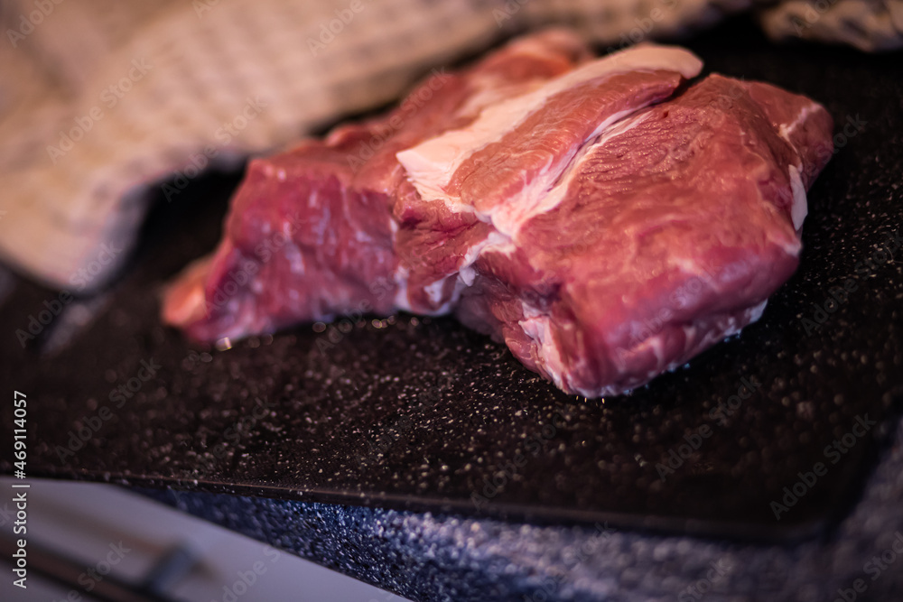 a piece of meat, pork meat on a cutting board, raw red meat, fresh meat on the kitchen table a piece of meat, pork meat on a cutting board, raw red meat, fresh meat on the kitchen table