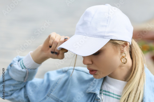 Photography Young woman adjusting her baseball cap outdoors