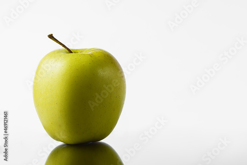 Green and yellow apple on a white background in a mirror image