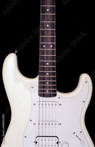 White electric guitar on a dark background close up