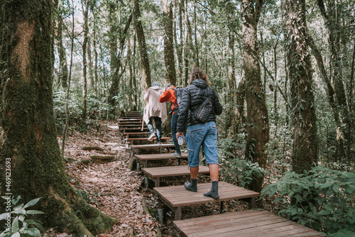 Three men travelers walking in jungle forest