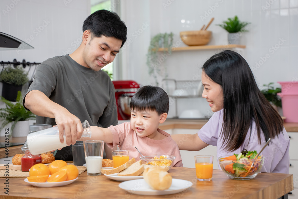 happy family together. Asian parent eating breakfast with little son in the kitchen. happy family together. Asian parent eating breakfast with little son in the kitchen.
