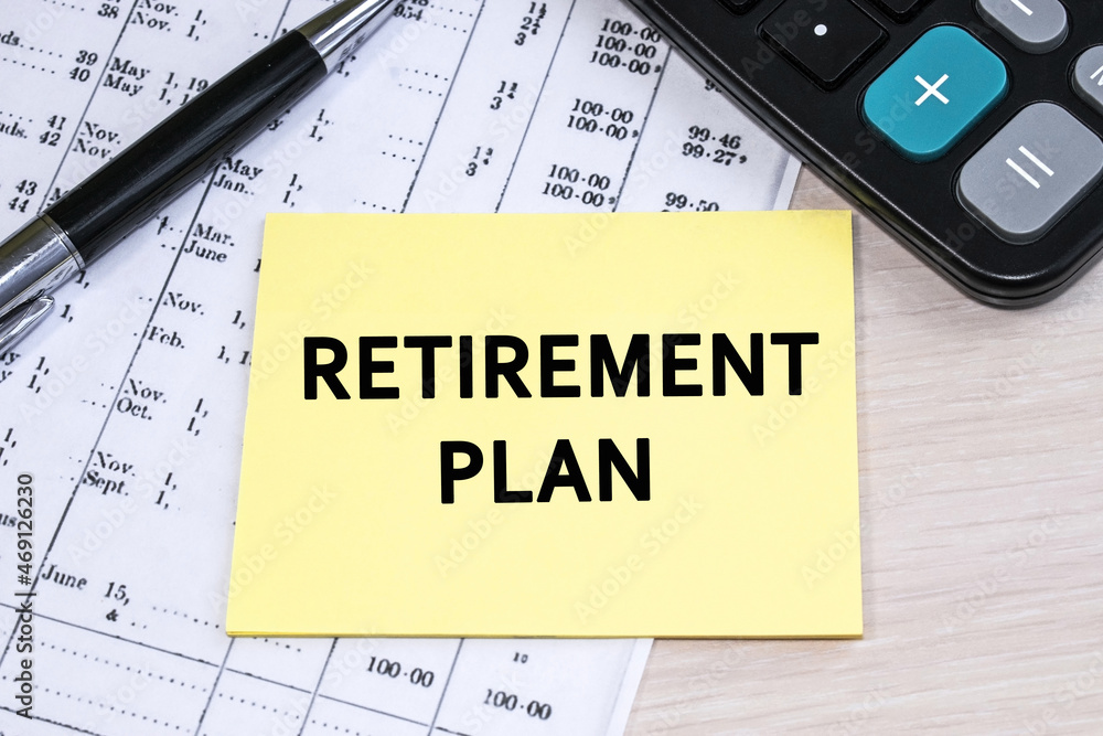 Retirement plan is written on a yellow sheet. Financial document with numbers and black calculator Retirement plan is written on a yellow sheet. Financial document with numbers and black calculator