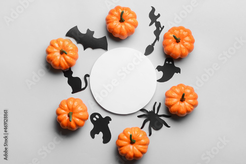 Blank paper sheet with Halloween decor and pumpkins on light background
