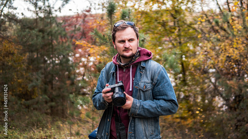 Photographer photographing in autumn forest. Travel and hobbie concept. day.