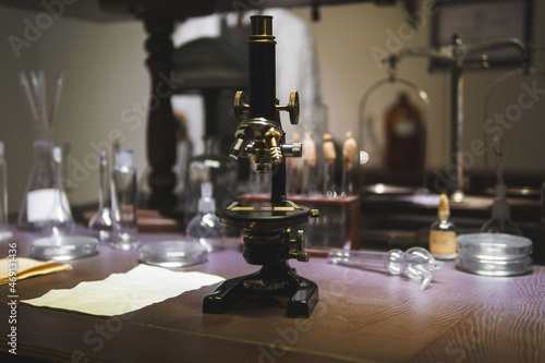 Vintage old microscope on table for science background. Medicine  alchemy  pharmacist. glass jars  flasks and tools  Selective focus