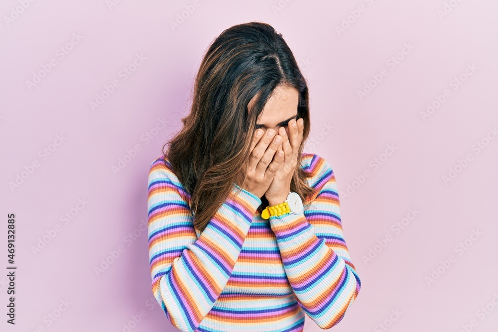 Young hispanic girl wearing casual clothes with sad expression covering face with hands while crying. depression concept. Young hispanic girl wearing casual clothes with sad expression covering face with hands while crying. depression concept.