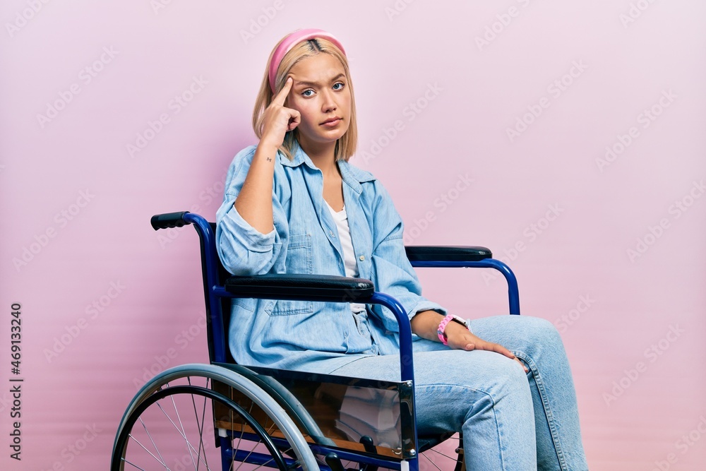 Beautiful blonde woman sitting on wheelchair pointing unhappy to pimple on forehead, ugly infection of blackhead. acne and skin problem Beautiful blonde woman sitting on wheelchair pointing unhappy to pimple on forehead, ugly infection of blackhead. acne and skin problem