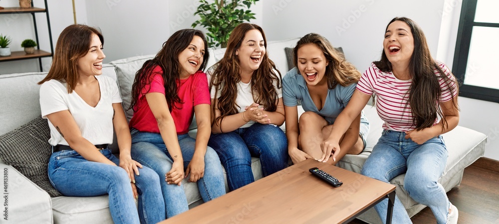 Obraz premium Group of young women friends smiling happy sitting on the sofa at home.