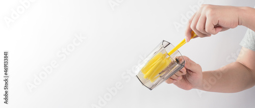 Clean and wash dish concept. Man hand washing drink glass on white background. Used drinking glass cleaning by soft yellow sponge stick. Wash cup by sponge brush. Disinfection hyginic in covid 19 era