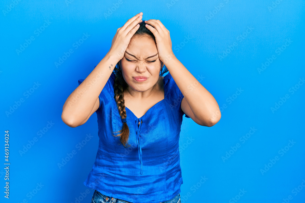 Young hispanic girl wearing casual clothes suffering from headache desperate and stressed because pain and migraine. hands on head.