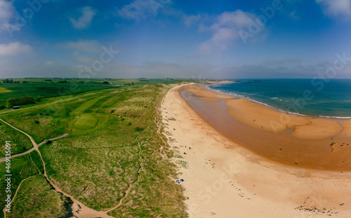 Embleton Bay and Burn sandy beach with the ruins of Dunstanburgh Castle