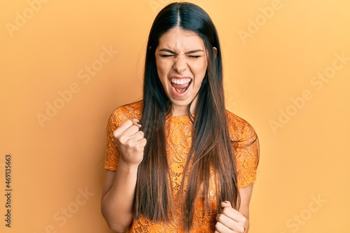 Young hispanic woman wearing casual clothes celebrating surprised and amazed for success with arms raised and eyes closed
