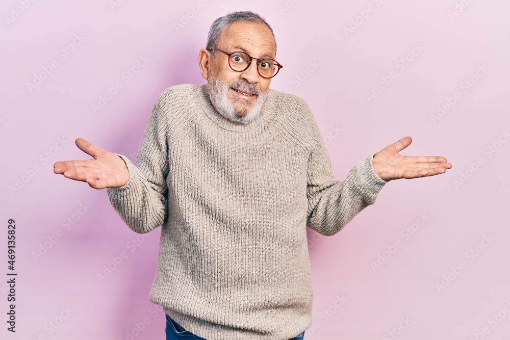 Handsome senior man with beard wearing casual sweater and glasses smiling showing both hands open palms, presenting and advertising comparison and balance Handsome senior man with beard wearing casual sweater and glasses smiling showing both hands open palms, presenting and advertising comparison and balance