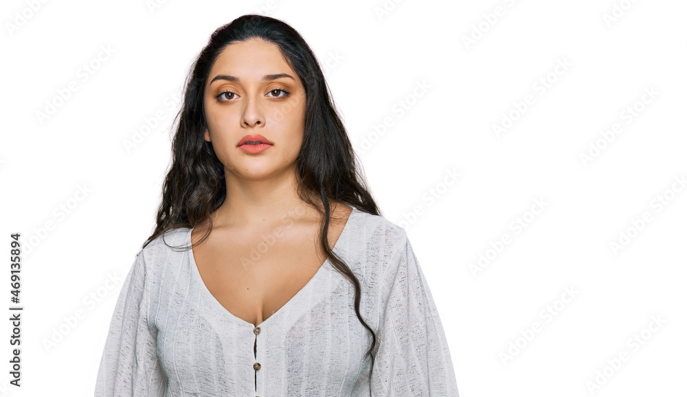 Brunette young woman wearing casual clothes relaxed with serious expression on face. simple and natural looking at the camera. Brunette young woman wearing casual clothes relaxed with serious expression on face. simple and natural looking at the camera.