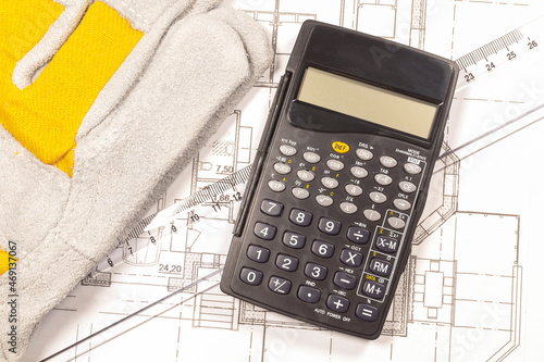 Work gloves, engineer calculator and ruler on the house plan. 