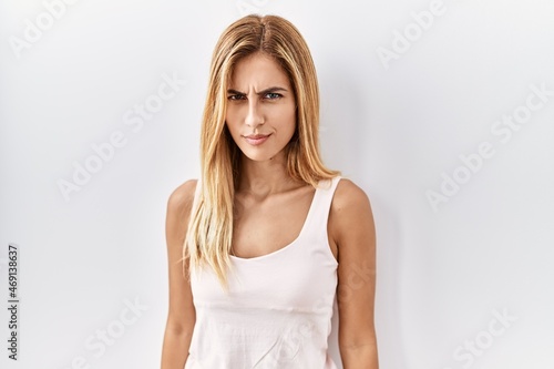 Blonde beautiful young woman standing over white isolated background skeptic and nervous, frowning upset because of problem. negative person.