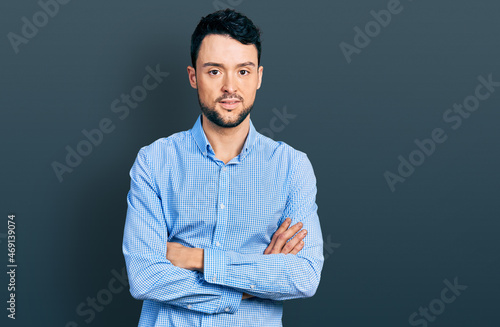 Hispanic man with beard with arms crossed gesture relaxed with serious expression on face. simple and natural looking at the camera.