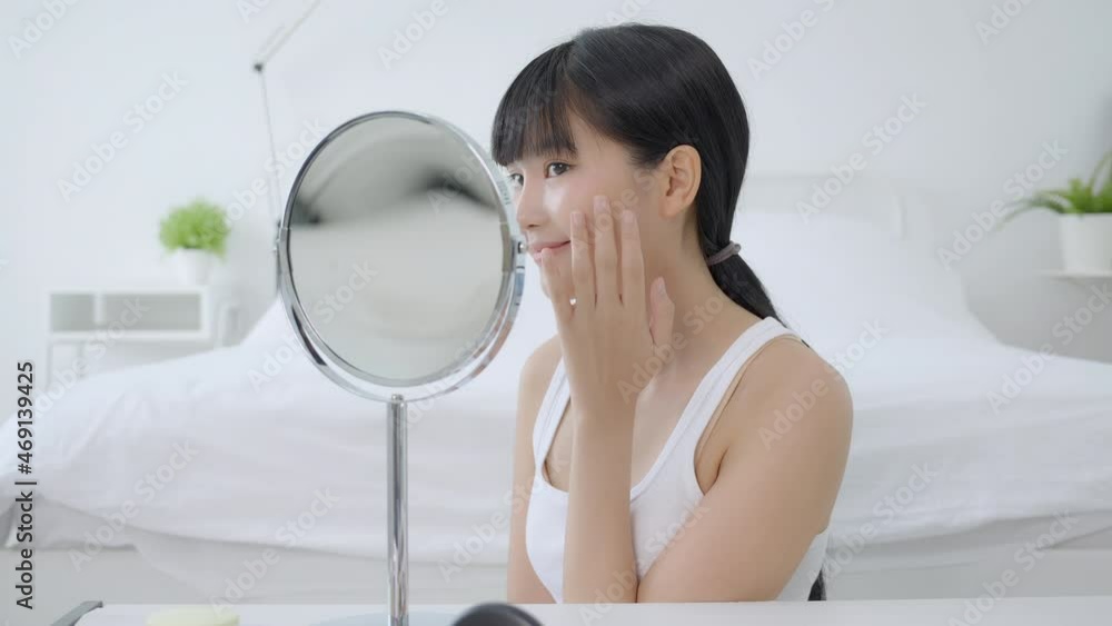 Beautiful face of young asian woman with happy smiling and touch cheek looking mirror with charming, makeup of beauty facial girl with skincare and cosmetic treatment, skin care and healthy concept. Beautiful face of young asian woman with happy smiling and touch cheek looking mirror with charming, makeup of beauty facial girl with skincare and cosmetic treatment, skin care and healthy concept.