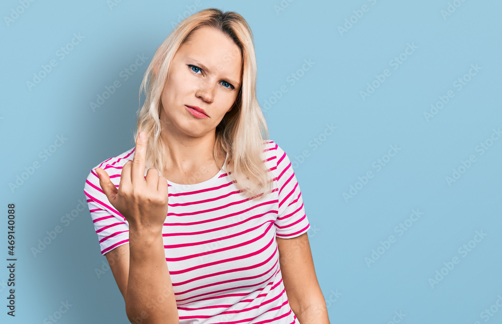 Young caucasian woman wearing casual clothes showing middle finger, impolite and rude fuck off expression Young caucasian woman wearing casual clothes showing middle finger, impolite and rude fuck off expression