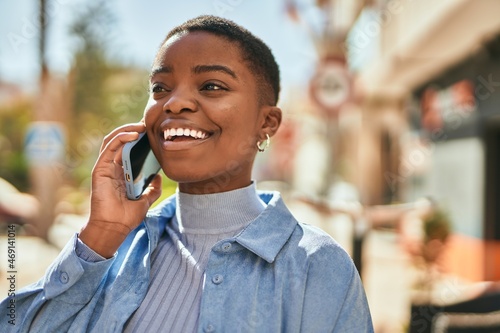 Young african american woman smiling happy talking on the smartphone at the city