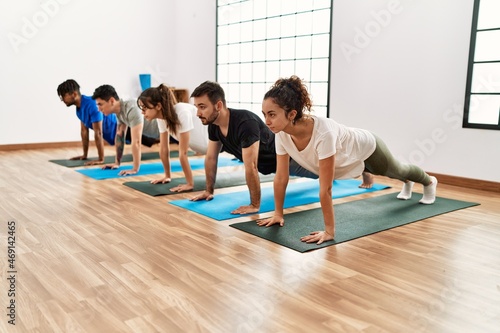 Group of young sporty people concentrate training yoga at sport center.