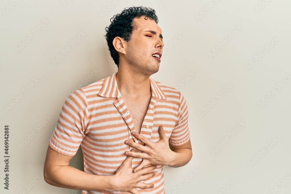 Handsome man wearing make up wearing casual t shirt with hand on stomach because nausea, painful disease feeling unwell. ache concept. Handsome man wearing make up wearing casual t shirt with hand on stomach because nausea, painful disease feeling unwell. ache concept.