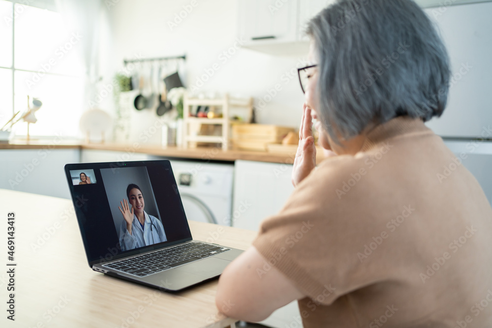 Asian senior older woman video call with doctor in living room at home. Asian senior older woman video call with doctor in living room at home.