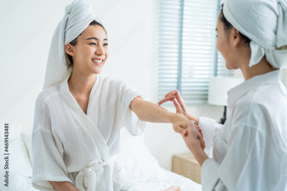 Asian lesbian gay couple enjoy put smooth and soft skin care on hands. 