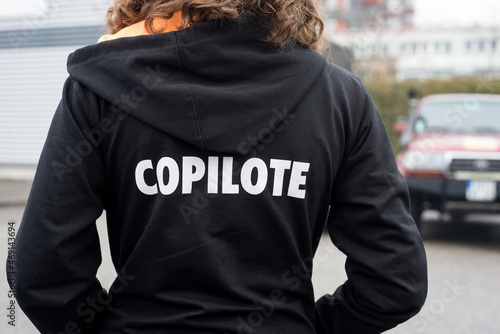 Closeup of girl wearing a black printed sweat shirt with text in french :  copilote, traduction in english : copilot photo