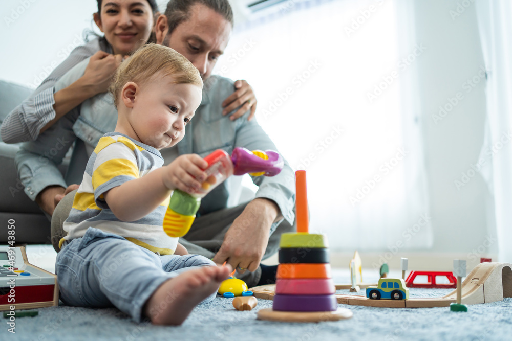 Caucasian happy loving parent play with baby toddler in living room. Caucasian happy loving parent play with baby toddler in living room.