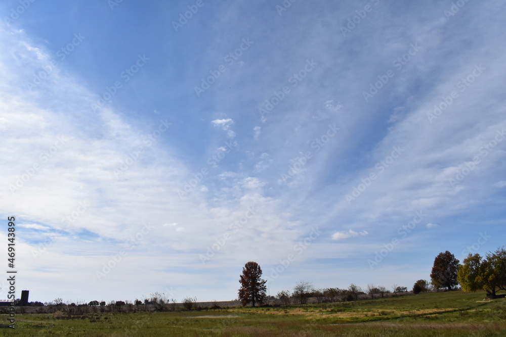 White Clouds in a Blue Sky Over a Rural Farm Field White Clouds in a Blue Sky Over a Rural Farm Field