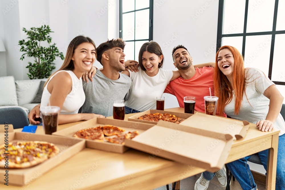 Group of young people smiling happy and hugging eating italian pizza at home. Group of young people smiling happy and hugging eating italian pizza at home.