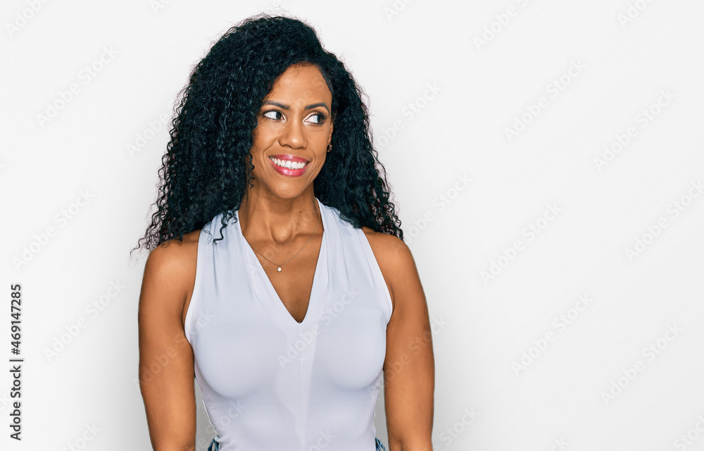 Middle age african american woman wearing casual style with sleeveless shirt smiling looking to the side and staring away thinking. Middle age african american woman wearing casual style with sleeveless shirt smiling looking to the side and staring away thinking.