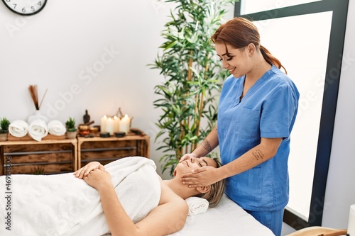 Woman couple smiling confident having facial massage at beauty center photo