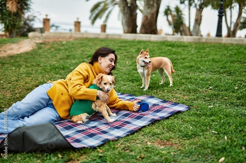 Beautiful young woman walking with shiba inu dog at park