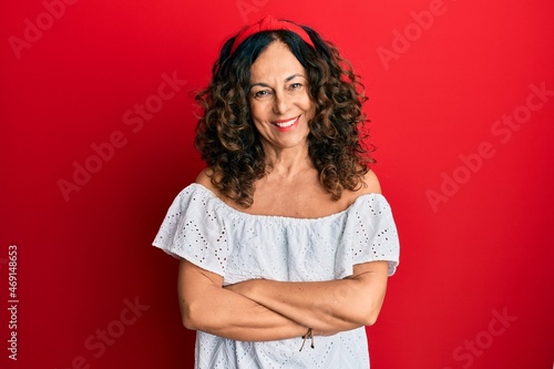Middle age hispanic woman wearing casual clothes happy face smiling with crossed arms looking at the camera. positive person.