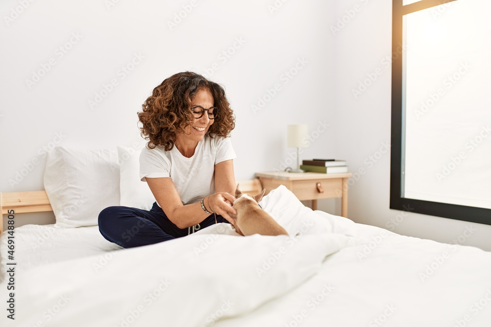 Middle age hispanic woman smiling confident holding chihuahua at bedroom Middle age hispanic woman smiling confident holding chihuahua at bedroom