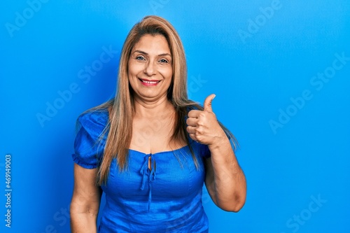 Middle age hispanic woman wearing casual clothes smiling happy and positive  thumb up doing excellent and approval sign