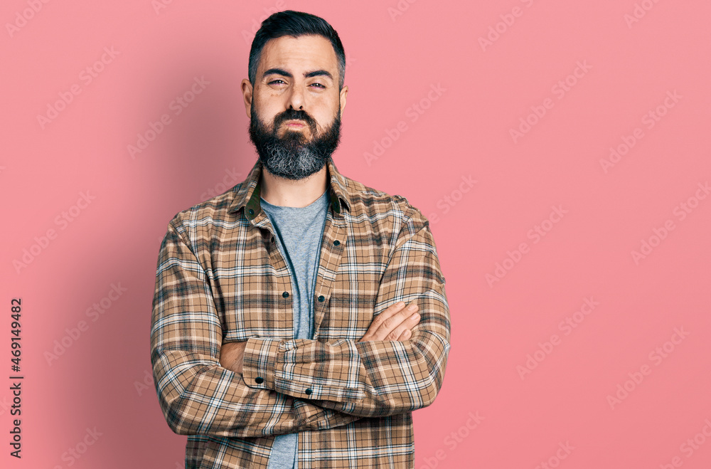 Fototapeta premium Hispanic man with beard with arms crossed gesture puffing cheeks with funny face. mouth inflated with air, catching air.